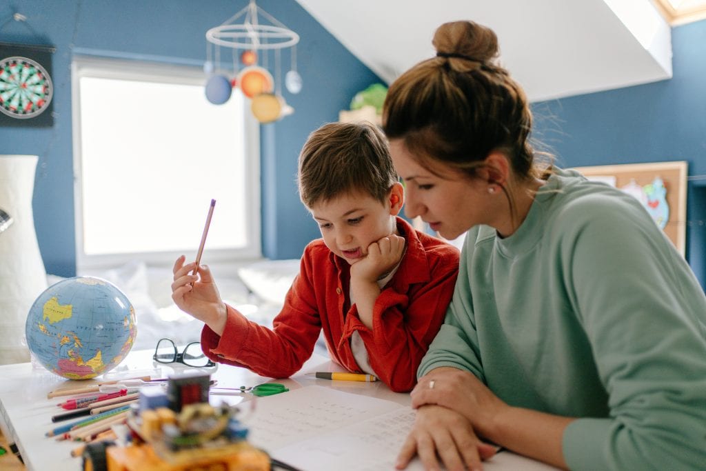 Mother and son homeschooling in a clean room