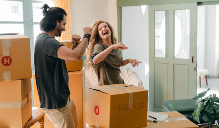 happy couple laughing and packing up to move out of their home