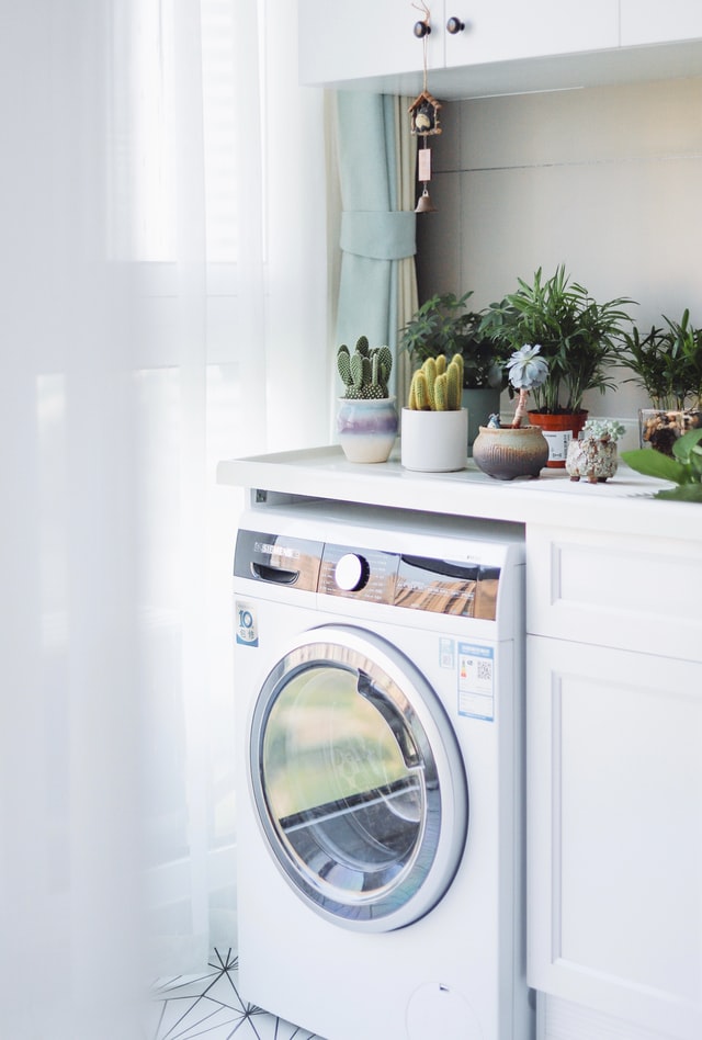 a clean dryer in a white laundry room