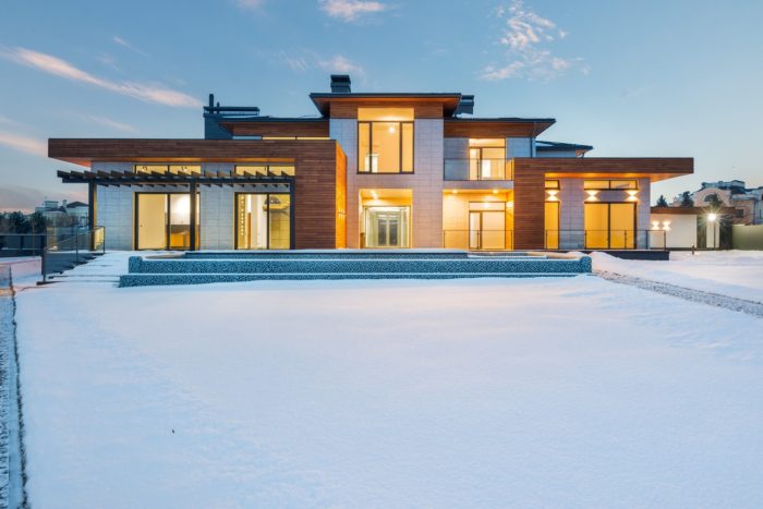 a snowy home with all of the lights on