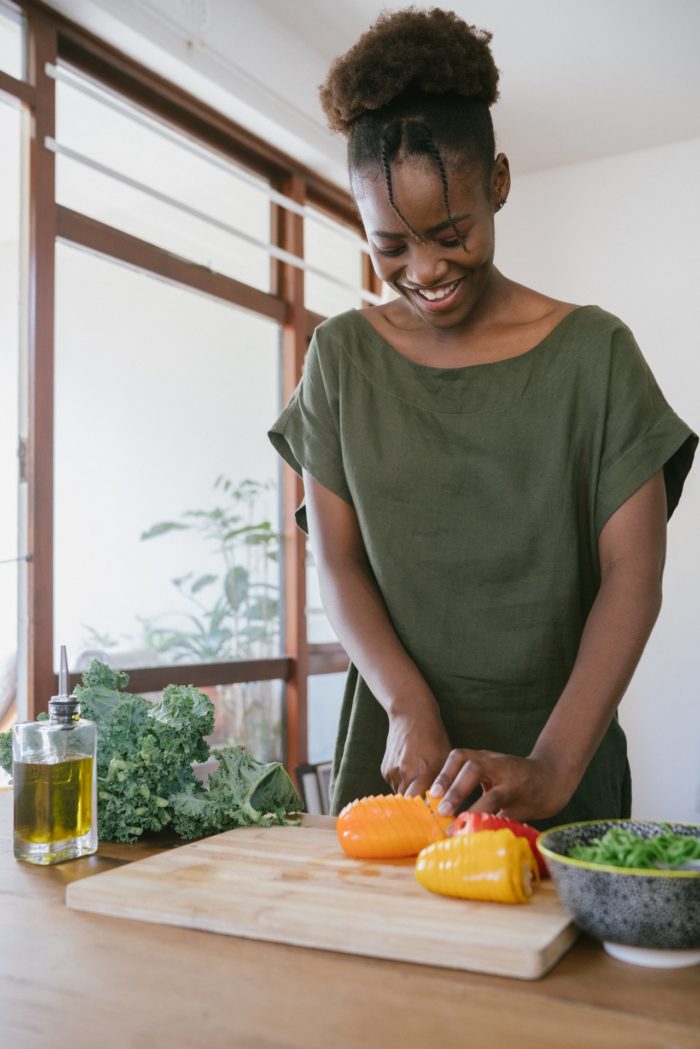 happy woman chopping vegetables in her kitchen