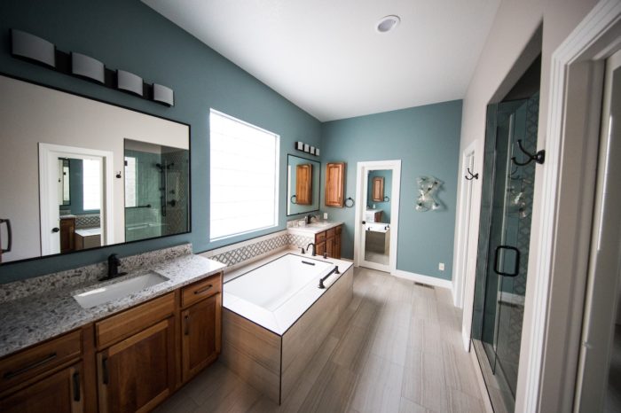 a very clean bathroom with a white tub and blue walls