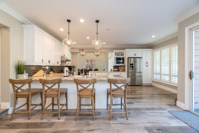 A bright clean kitchen with bar chairs 