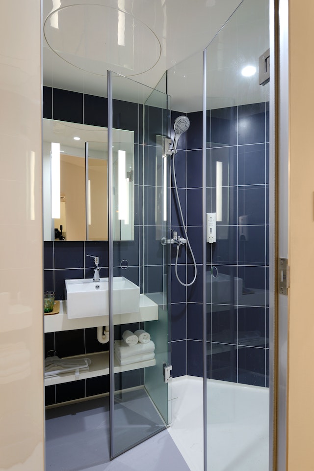 a clean and clutter free blue shower and white bathroom sink