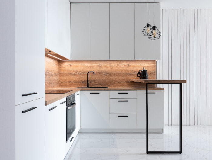 a clean white kitchen with wooden counters and backsplash